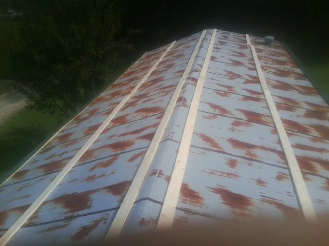 Rusted metal roof panels with new wood purlins before replacement — Storm Damage Roof Repair in Haslett by Roofing Brothers