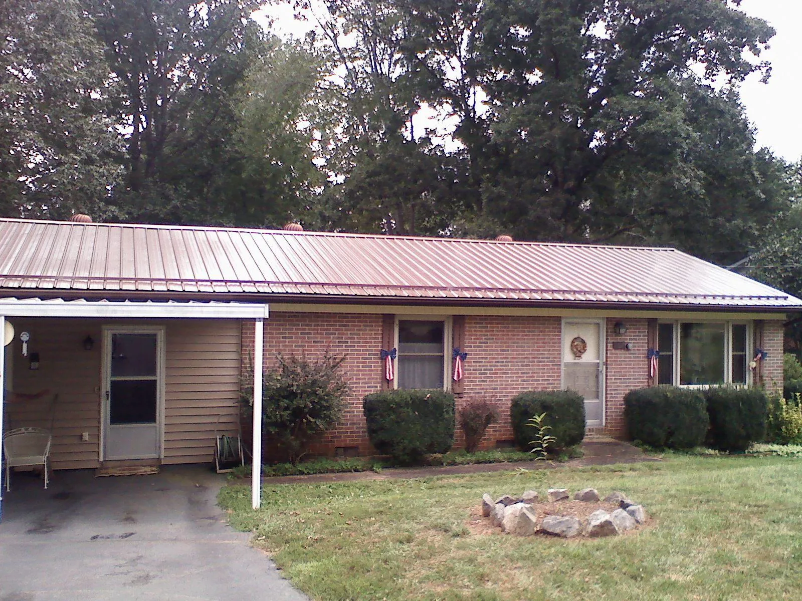 Bronze metal roof and carport on a brick ranch home — Roof Repair work by our crew in Haslett