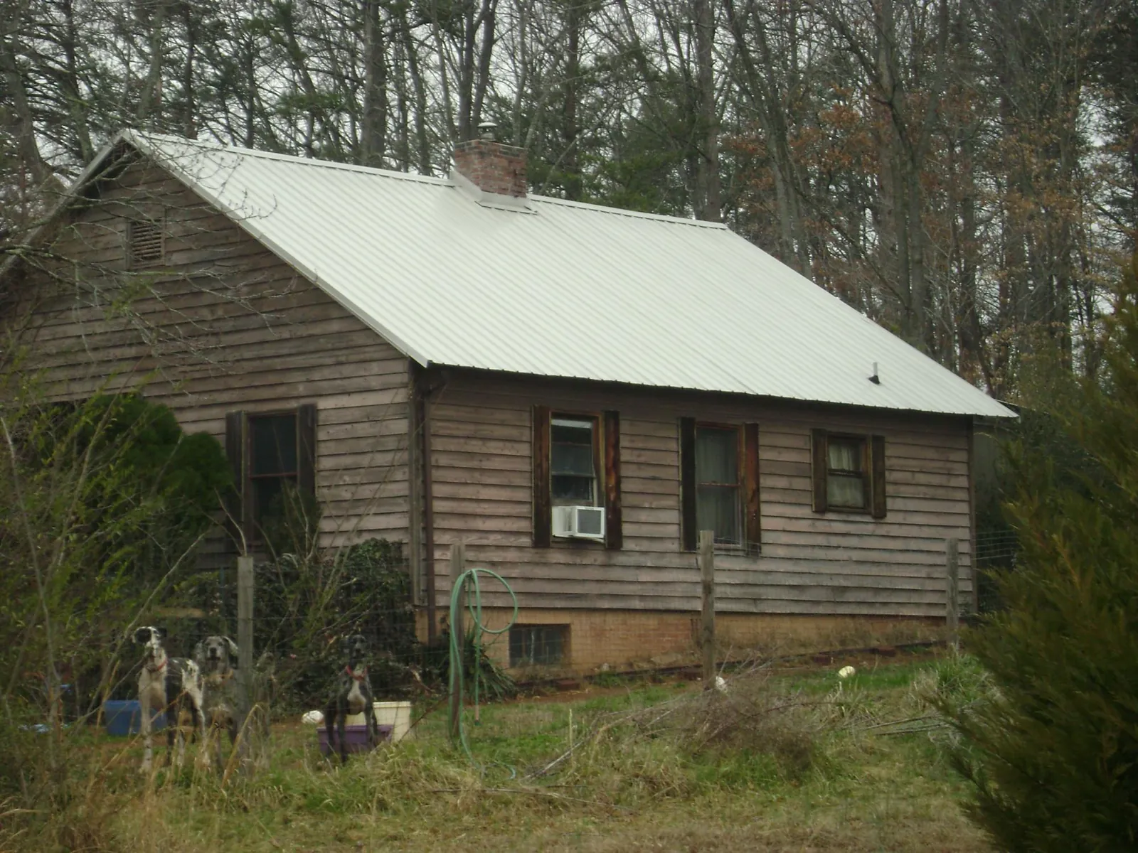 White metal roof on an old wood sided farmhouse, from a Metal Roof Installation job in Haslett